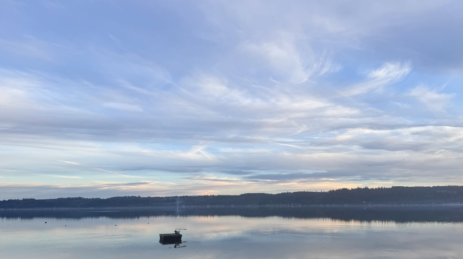 Still water at dusk with boat on Hood Canal near Quilcene, Washington
